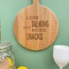 ronde houten borrelplank met quote in lasergravure: Less talking and more snacks